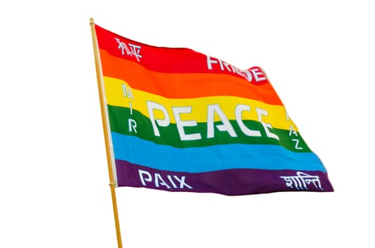 Waving rainbow varicolored pacifist flag with multilingual peace text wind fluttering isolated on white background