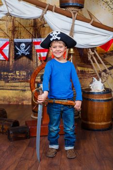 Cute little boy wearing pirate costume on the deck of a ship