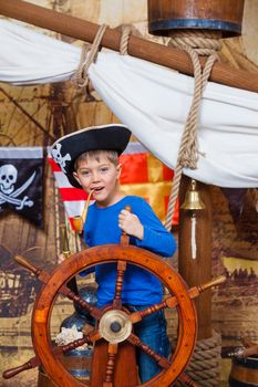 Cute little boy wearing pirate costume on the deck of a ship
