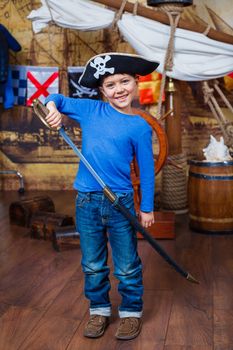 Cute little boy wearing pirate costume on the deck of a ship