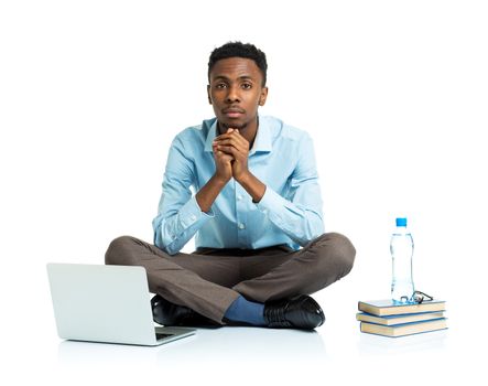 African american college student with laptop, books and bottle of water sitting on white background