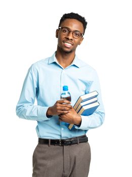Happy african american college student with books and bottle of water in his hands  standing on white background
