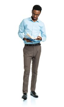 Happy african american college student with books in his hands  standing on white background