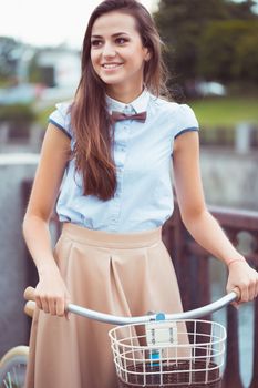 Young beautiful, elegantly dressed woman with bicycle. Beauty, fashion and lifestyle