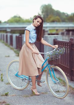 Young beautiful, elegantly dressed woman with bicycle. Beauty, fashion and lifestyle