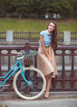 Young beautiful, elegantly dressed woman with bicycle. Beauty, fashion and lifestyle