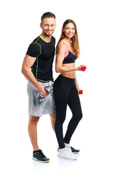 Sport couple - man and woman with dumbbells on the white background