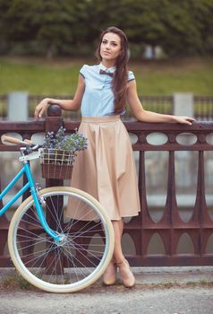 Young beautiful, elegantly dressed woman with bicycle. Beauty, fashion and lifestyle