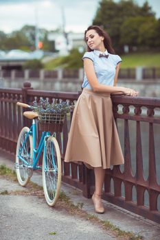 Young beautiful, elegantly dressed woman with bicycle. Beauty, fashion and lifestyle