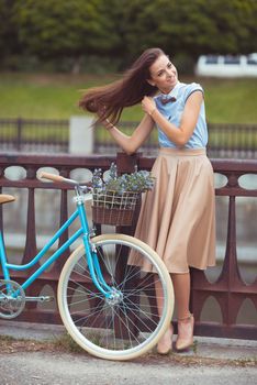 Young beautiful, elegantly dressed woman with bicycle. Beauty, fashion and lifestyle