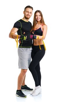 Happy sport couple - man and woman with measuring tape and ginger up on the white background