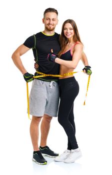 Happy sport couple - man and woman with measuring tape and ginger up on the white background