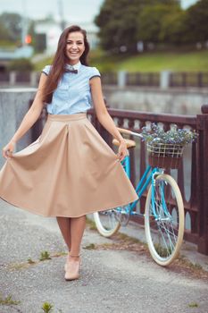 Young beautiful, elegantly dressed woman with bicycle. Beauty, fashion and lifestyle