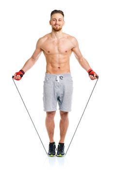 Athletic attractive man jumping on a rope on the white background