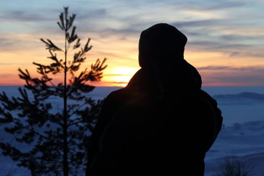 man in  the sunset on the Gulf of Finland with trees