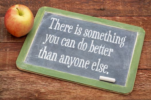 There is something you can do better than anyone else - positive words on a slate blackboard against red barn wood