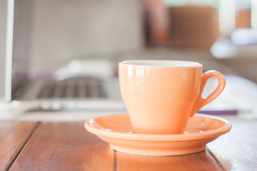 Orange coffee cup on work station, stock photo