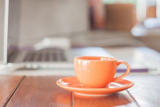 Mini orange coffee cup on work station, stock photo