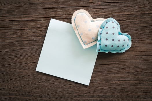Blue hearts handmade crafts from polka dot cotton cloth with blank notepad place on wood background with vignette, wedding and anniversary symbol
