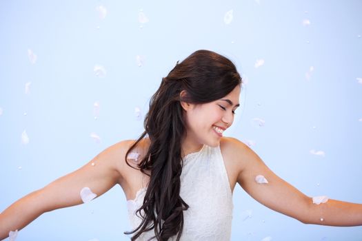 Profile of beautiful biracial bride in wedding dress, smiling, arms outstretched