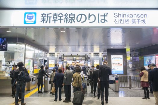 Osaka, Japan - Nov 1: Commuters going through the ticket gates in a Shinkansen bullet train station in Japan on Nov 1, 2014. The Shinkansen is a netwrok of high-speed railway lines in Japan.