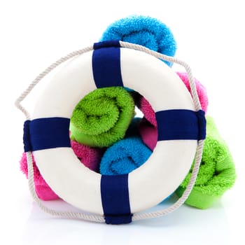 summer gear; colorful towels and life buoy over white background