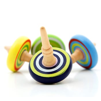 Four colorful wooden Spinning tops iver white background