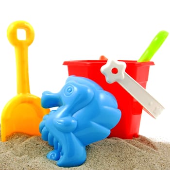 beach toys in sand over white background