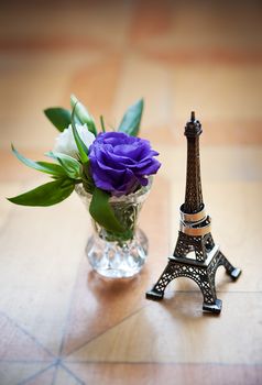 statuette of Eiffel Tower and wedding rings with flower
