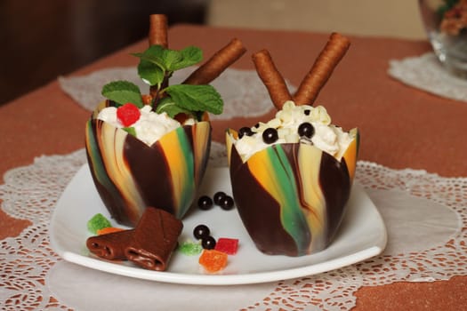 Chocolate tulip cups filled with curd dessert decorated with candied pineapple and chocolate chips