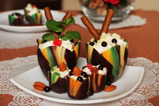 Chocolate tulip cups filled with curd dessert decorated with candied pineapple and chocolate chips