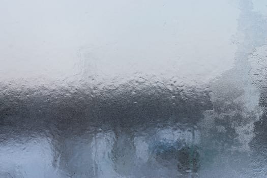 frozen window glass covered with patterned ice