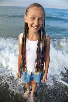 Portrait of a girl with long braids on her head to the sea
