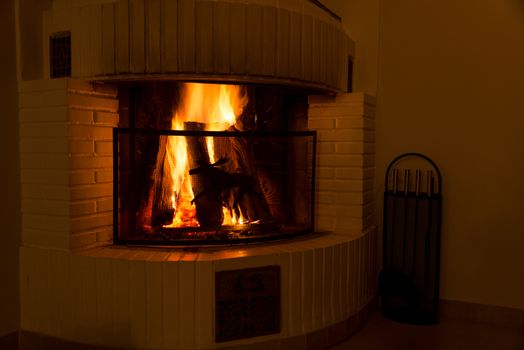 Vintage fireplace with burning logs. Renewable energy concept.