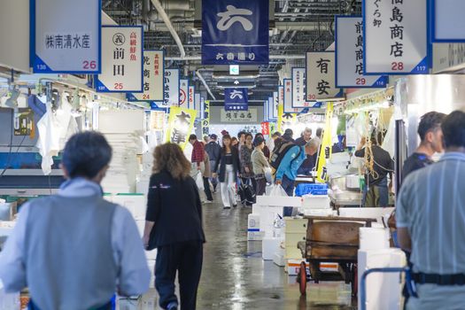 Osaka, Japan - Oct 25: People shopping in a fresh food market in Osaka, Japan on Oct 25, 2014. The market offers a wide range of food, including seafood, vegetables and fruits.