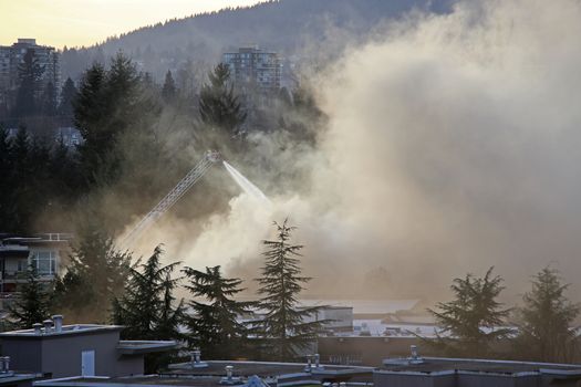 Coquitlam, BC, Canada - February 16, 2015 : Firefighter crews battling apartment complex fire on Glen drive in Coquitlam.