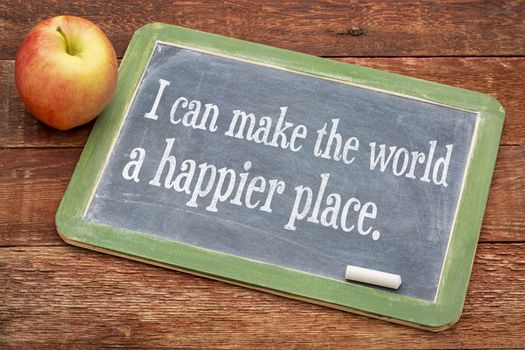 I can make the world a happier place - positive words on a slate blackboard against red barn wood