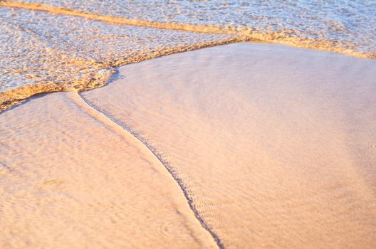 Transparent wave of the sea on the sandy beach