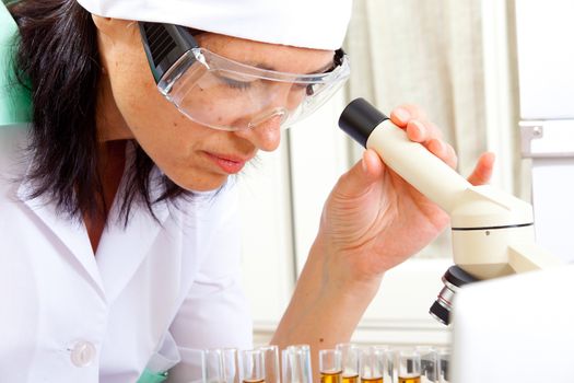 female scientist microscoping in the life science research laboratory (genetics, biochemistry, forensics, microbiology)