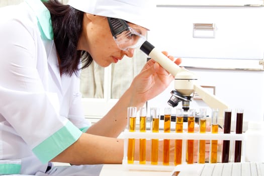 female scientist microscoping in the life science research laboratory (genetics, biochemistry, forensics, microbiology)