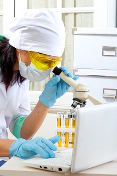 scientist looking into microscope at the lab