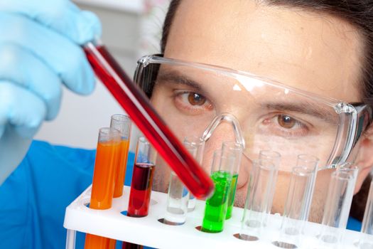 Lab worker examining contents of a test tube