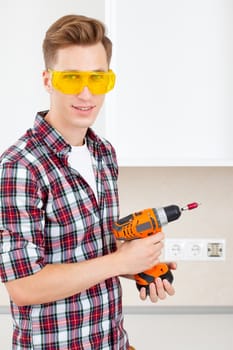 builder in eyeglasses and with a drill in his hands