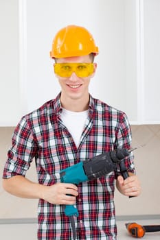 smiling worker in protective eyeglasses and orange helmet with rock-drill