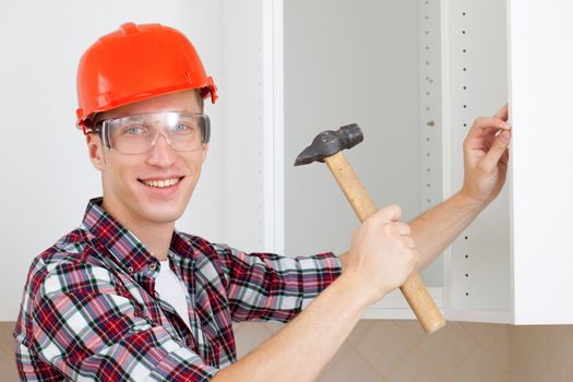 young smiling worker with a hammer