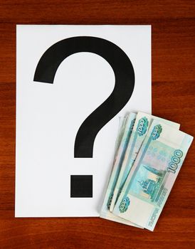 Russian Currency and Question Mark on the Wooden Background