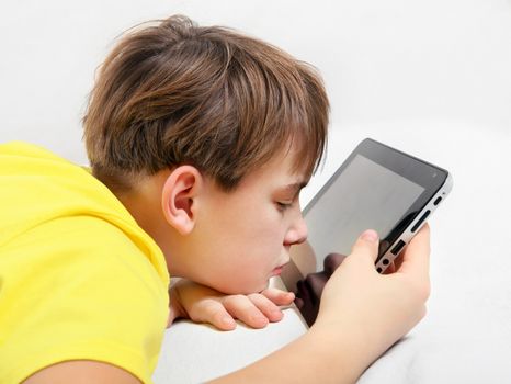 Tired Kid with Tablet Computer on the Bed