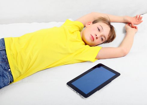 Tired Kid with Tablet Computer on the Bed