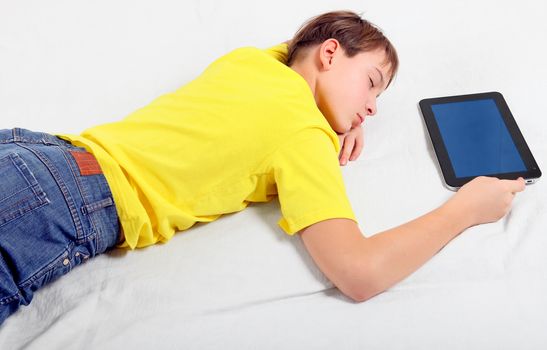 Tired Kid sleep with Tablet Computer on the Bed