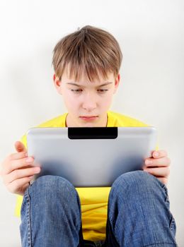 Sad Kid with Tablet Computer on the White Background